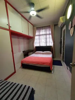 a bedroom with a red bed and a window at The Handz House II with WIFI - For family or same gender only in Kepala Batas
