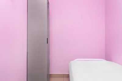a bathroom with a toilet and a pink wall at Hotel O City Hostel Ipoh in Ipoh