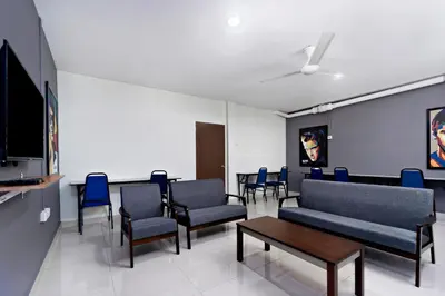 a waiting room with chairs and couches and a tv at Hotel O City Hostel Ipoh in Ipoh