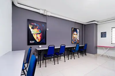 a conference room with a table and blue chairs at Hotel O City Hostel Ipoh in Ipoh