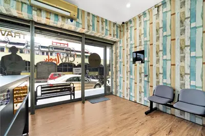 a room with two chairs in front of a store at Hotel O City Hostel Ipoh in Ipoh