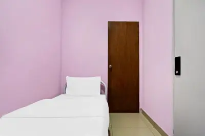 a small room with a bed and a door at Hotel O City Hostel Ipoh in Ipoh