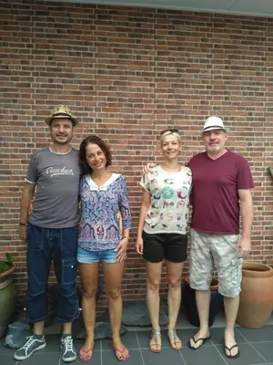 a group of people standing in front of a brick wall at Austin Homestay in Ipoh