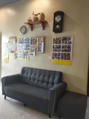a living room with a couch and clocks on the wall at Austin Homestay in Ipoh