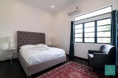 a bedroom with a bed and a chair and a window at Jomstay Mayhaven Villa (Ipoh) in Ipoh