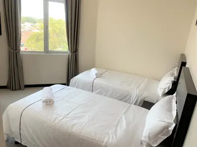 a hotel room with two beds and a window at DCozy Hotel in Perai