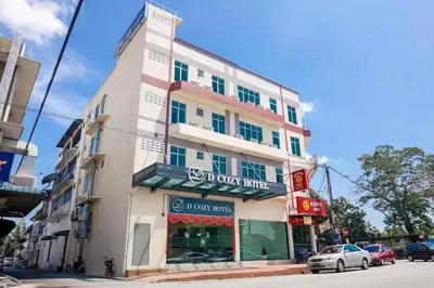 a tall white building with a sign on it at DCozy Hotel in Perai