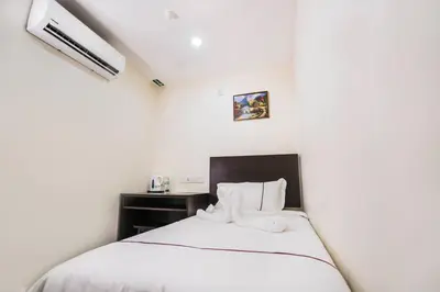 a bedroom with a bed with white sheets and white pillows at DCozy Hotel in Perai