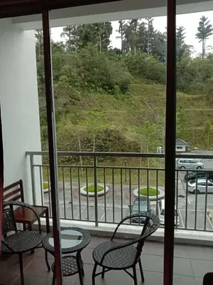 a balcony with chairs and tables and a view of a parking lot at Galina Somersquare Goldenhills Aprt Pasar Malam Cameron Highlands in Brinchang