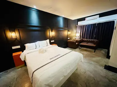 a hotel room with a large bed and a couch at CJ HOUSE station 18 Ipoh in Ipoh