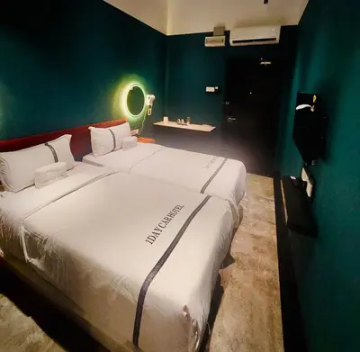 a large white bed in a room with a green wall at CJ HOUSE station 18 Ipoh in Ipoh
