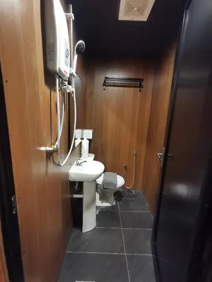 a bathroom with a toilet and a sink and a tv at Tatami D'Tepi Laut - PANGKOR ISLAND in Pangkor