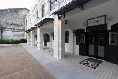 a row of buildings with doors and a street at Macalister Terraces Hotel in George Town