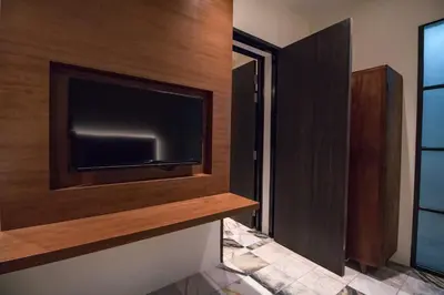 a living room with a tv on a wall at Macalister Terraces Hotel in George Town