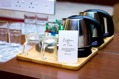 affeepot and glasses on a wooden tray with a coffee on top at Macalister Terraces Hotel in George Town