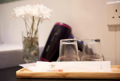a table with two glasses and a vase with flowers at Macalister Terraces Hotel in George Town