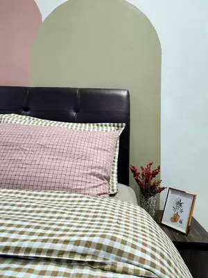 a bed with a black headboard and a picture on a table at Rara Homestay Kuala Kangsar in Kuala Kangsar
