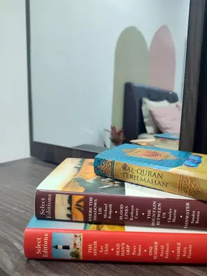 three books stacked on top of each other on a table at Rara Homestay Kuala Kangsar in Kuala Kangsar