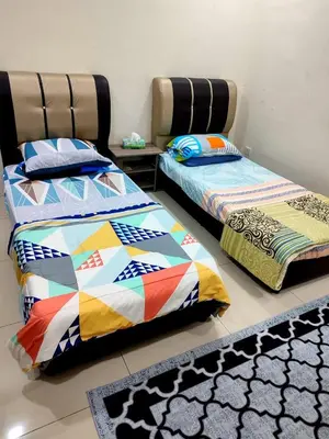 two beds sitting next to each other in a room at Rara Homestay Kuala Kangsar in Kuala Kangsar
