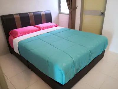 a bedroom with a bed with blue and pink sheets at My Homestay N18 (14 pax) @ Golden Hills Night Market in Brinchang