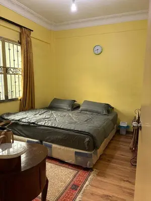 a bedroom with a bed and a clock on the wall at Muslim Apartment Homestay in Tanah Rata