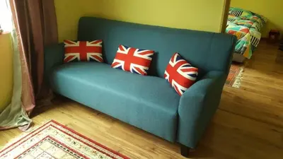 a blue couch with red and white pillows on it at Muslim Apartment Homestay in Tanah Rata