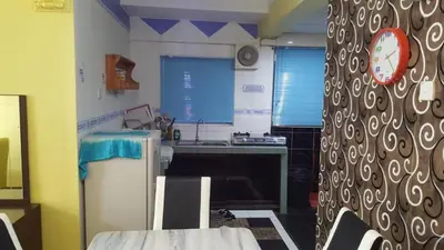 a kitchen with a sink and a table and a clock at Muslim Apartment Homestay in Tanah Rata