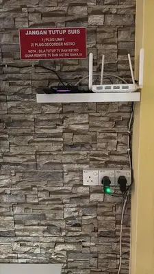 a sign on a stone wall with a video game controller at Muslim Apartment Homestay in Tanah Rata