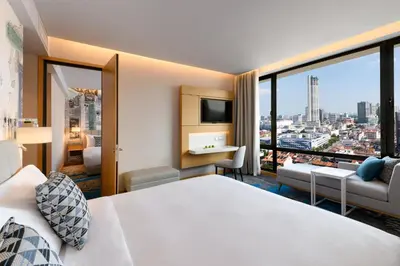 a hotel room with a bed and a view of a city at OZO George Town Penang in George Town