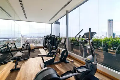 a gym with treadmills and ellipticals in a room with windows at OZO George Town Penang in George Town