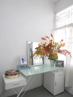 a glass desk with a mirror and flowers on it at little heritage home in George Town