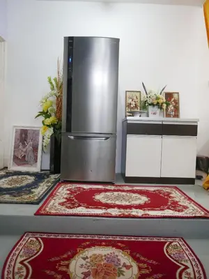 a kitchen with a refrigerator and two rugs at little heritage home in George Town