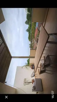 a view of a living room with a table and chairs at By the sea Duplex penthouse baby in Batu Ferringhi