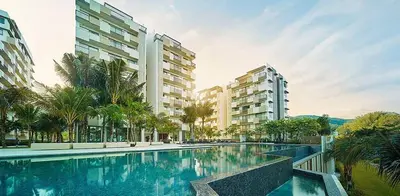 a large swimming pool with palm trees and buildings at By the sea Duplex penthouse baby in Batu Ferringhi
