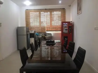 a room with a table and chairs and a soda machine at Island Hostel Bayan Lepas Airport in Bayan Lepas