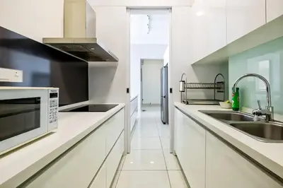 a white kitchen with a sink and a microwave at Jazz Service Suites Penang in George Town