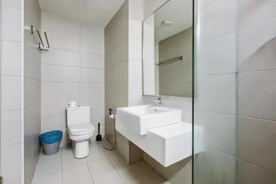 a white bathroom with a sink and a toilet at Jazz Service Suites Penang in George Town