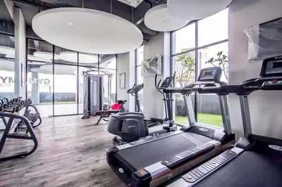 a gym with a treadmill and ellipticals in a room with windows at Jazz Service Suites Penang in George Town