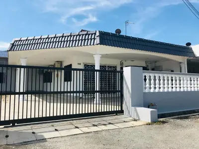 a white house with a black gate at CoZy and comfortable Homestay in sungai siput in Sungai Siput