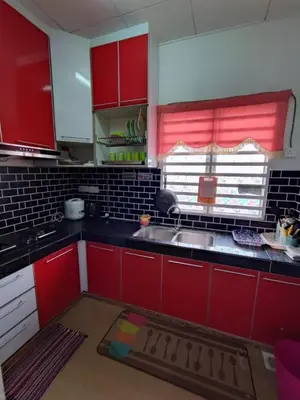 a kitchen with red cabinets and a sink and a window at Homestay D'Lily in Ipoh