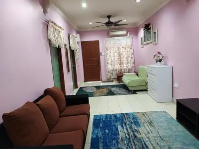 a living room with a brown couch and a green chair at Homestay D'Lily in Ipoh