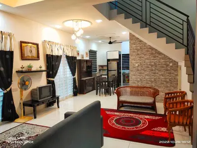 a living room with a couch and a tv and a kitchen at Sweet40 Homestay in Kampong Batu Lapan