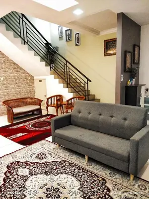 a living room with a couch and a staircase at Sweet40 Homestay in Kampong Batu Lapan