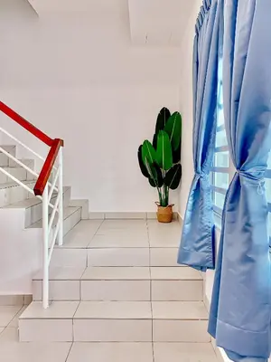 a staircase with blue curtains and a potted plant at Golden Sweet Home @ CH Golden Hills (Night Market) in Cameron Highlands