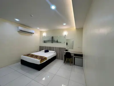 a bedroom with a bed and a desk in it at Avatel Bukit Mertajam in Bukit Mertajam