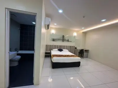a bedroom with a bed and a bathroom with a tub at Avatel Bukit Mertajam in Bukit Mertajam