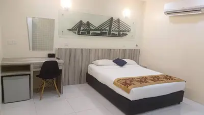 a bedroom with a bed and a desk and a computer at Avatel Bukit Mertajam in Bukit Mertajam