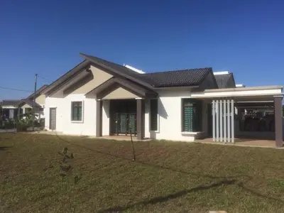 a white house with a grass yard at Cozy Corner Homestay in Kepala Batas