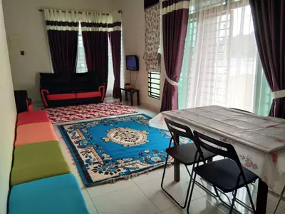 a bedroom with a bed and a table and chairs at Cozy Corner Homestay in Kepala Batas