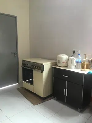 a kitchen with a stove and a counter top at Cozy Corner Homestay in Kepala Batas